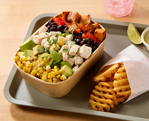 Chicken bowl with sweet potatoes, avocado, corn and other ingredients with waffle fries