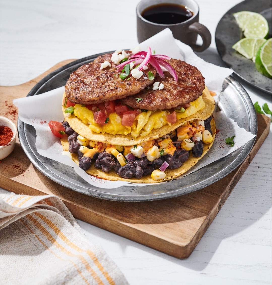 Breakfast tostadas with sausage links, egg, corn and black beans