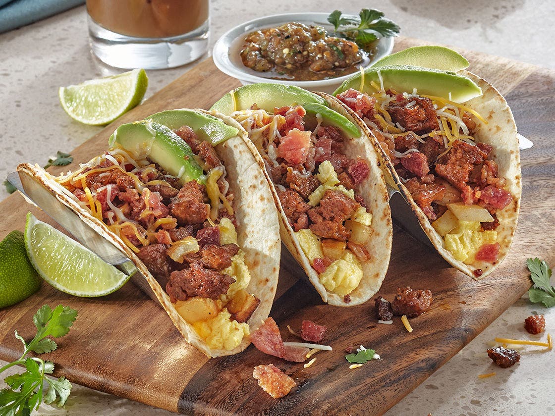 Mexican Original® tortilla shells filled with Hillshire Farm® chorizo crumbles, Jimmy Dean® bacon pieces, scrambled eggs, fried potatoes, shredded cheese and avocado slices