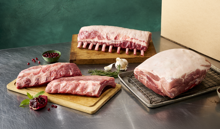 Raw rack of St. Louis-style pork ribs on metal prep tray