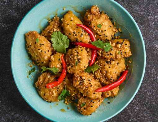 Spicy Honey Garlic Boneless Wings in a blue bowl