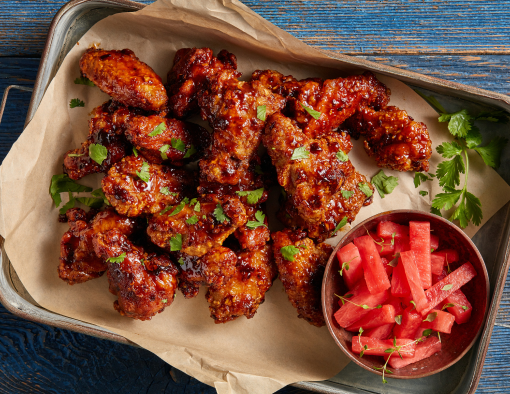 BBQ bone in chicken wings with pickled watermelon on a platter