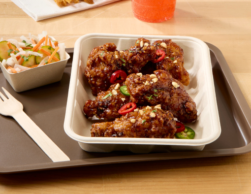 Tray of fried wings in hoisin sauce, topped with peanuts, Fresno peppers, sriracha mayo, and pickled salad