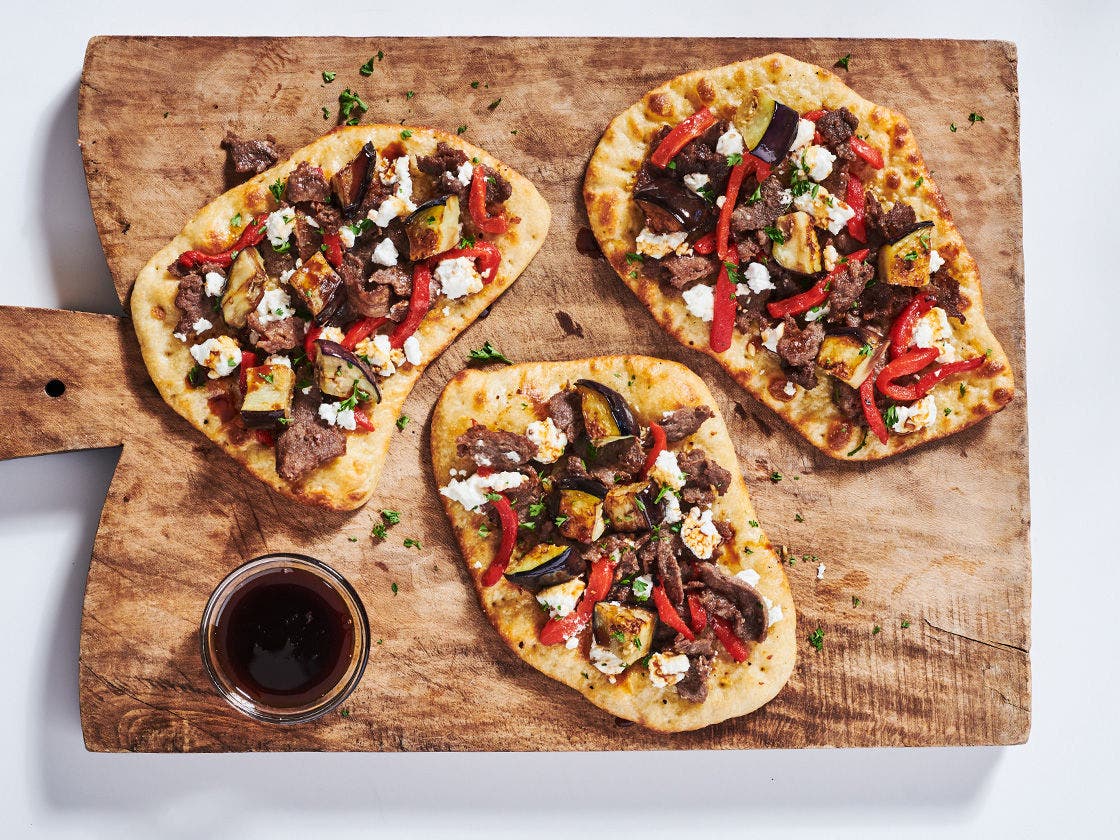 Lebanese flatbread with Original Philly® Sliced Beef, roasted red pepper, eggplant, goat cheese, parsley and side of pomegranate molasses