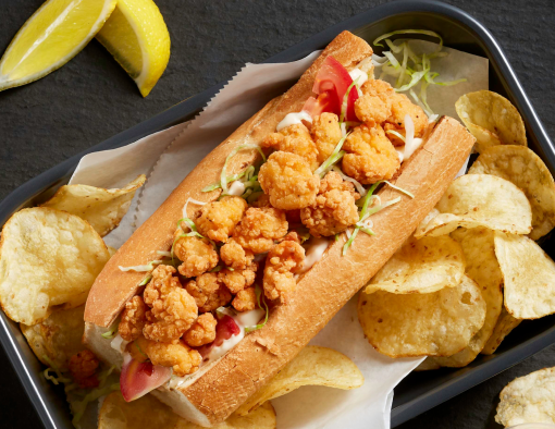 Tyson® Mini Chicken Bites served on a fresh chicken Po’ Boy Sandwich with a side of chips