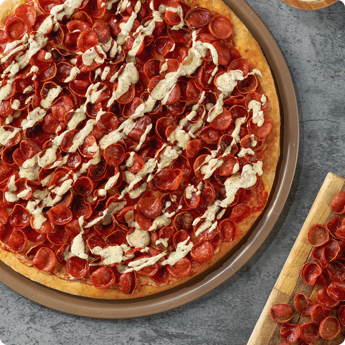 Thin-crust pizza loaded with cupping pepperoni and creamy drizzle