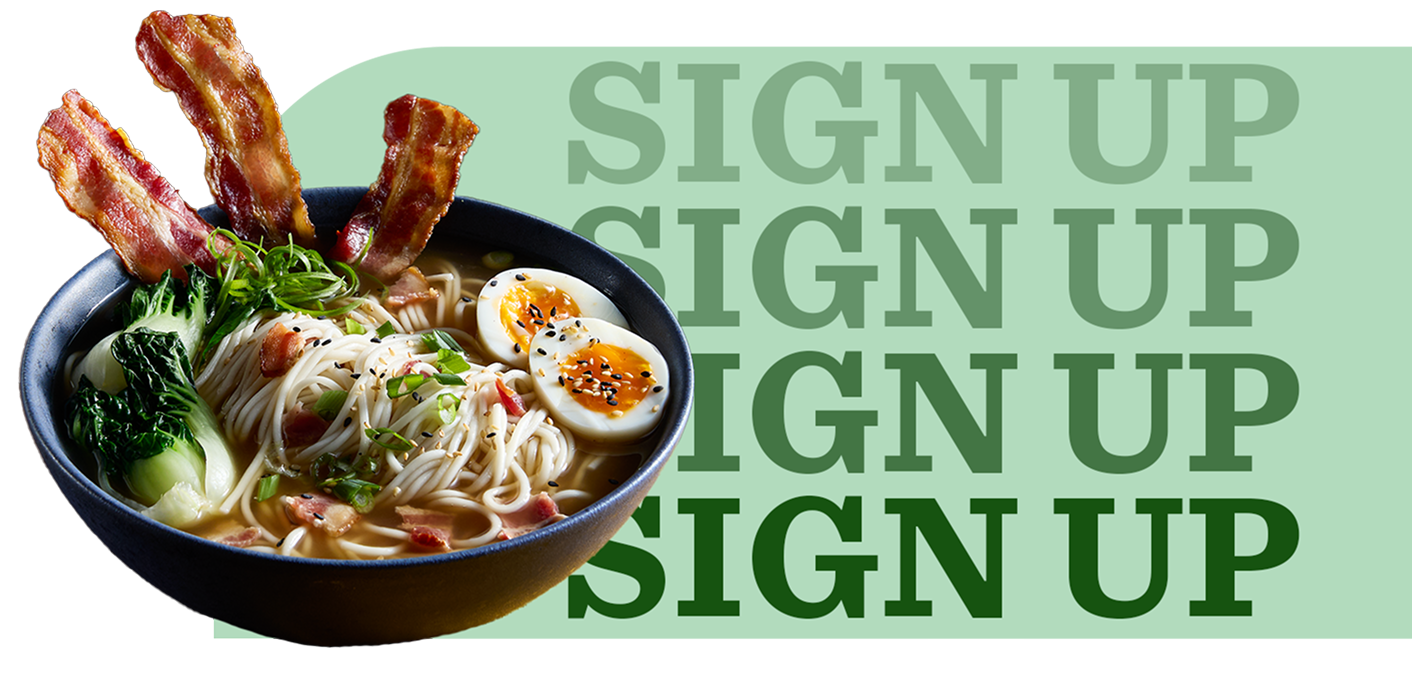 Ramen noodles, bacon, soft-boiled eggs and baby bok choy in a bowl of clear broth