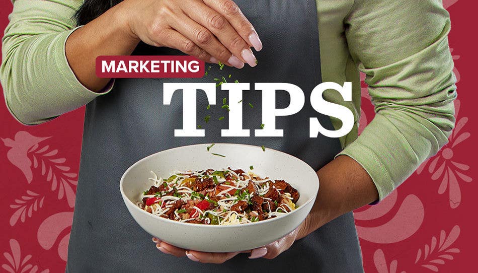 Chef in an apron holding a white bowl filled with chicken, shredded cheese and vegetables