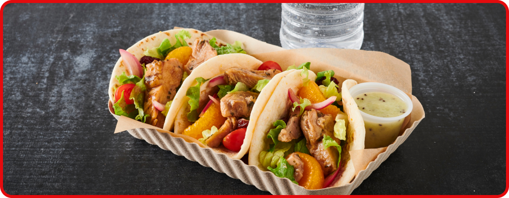 Three Tacos filled with meant and vegetables with a side of sauce