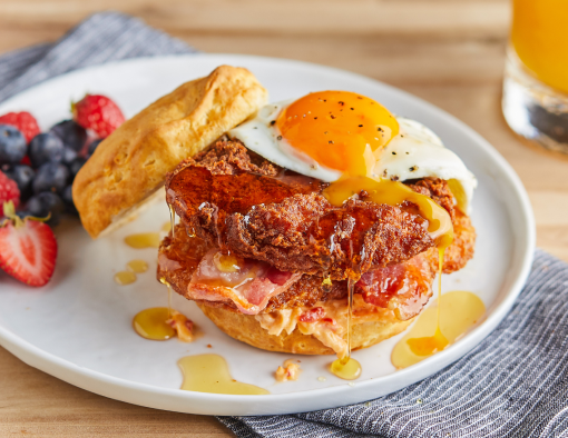 Spicy Breakfast Chicken Sandwich with a side of strawberries and blueberries
