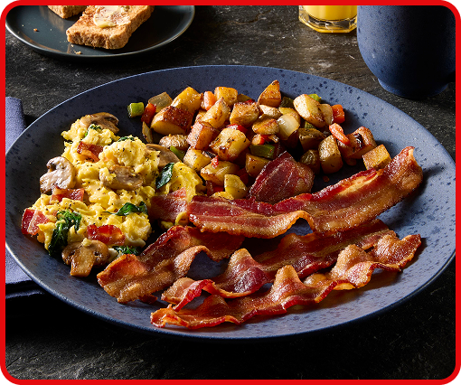 A plate featuring scrambled eggs, diced potatoes, with bacon, highlighted in the foreground