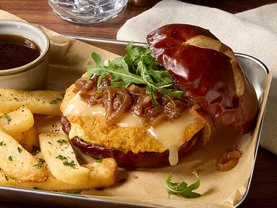 Crispy chicken breast with caramelized onions, Gruyere cheese, arugula on pretzel roll, side of steak fries