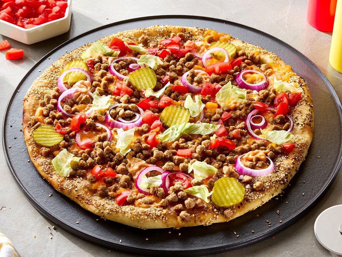 Sesame seed dusted pizza crust topped with Hillshire Farm® Cooked Beef Topping, signature burger sauce, tomato, red onion, pickles and lettuce