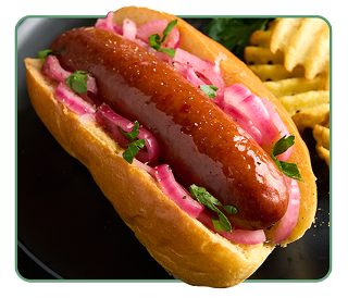 A hot dog bun stuffed with a thick smoked sausage and pickled onions with ripple chips on the side 