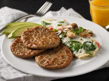 Omelet and breakfast sausage on a plate.