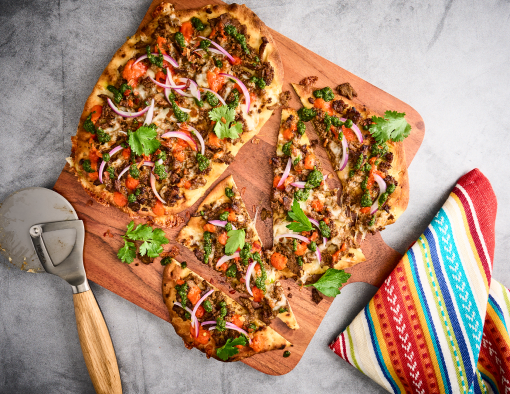 Chimi Steak Flatbread With a Pizza Slicer on a Serving Board