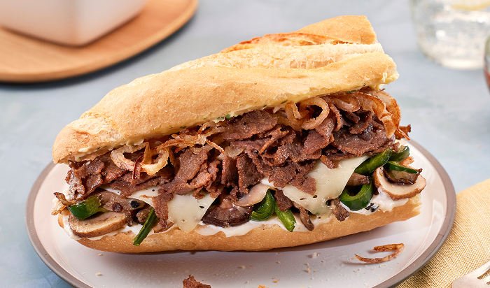 sandwich featuring Original Philly® Fully Cooked Seasoned Sliced Beef in restaurant setting
