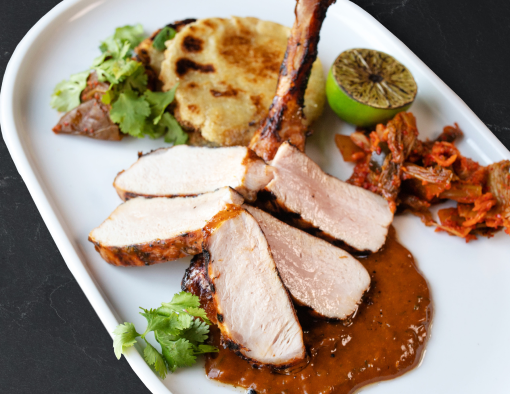 Pork Bulgogi With Potatgo Cakes, Half Lime and Sides Served on a White Plate