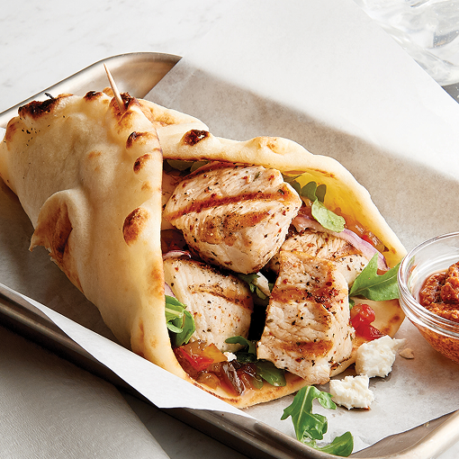 Chicken wrap with grilled chicken, fresh lettuce, tomatoes, and cheese, served with dipping sauce