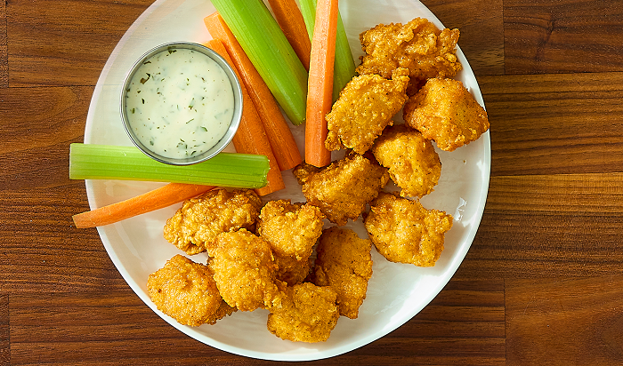Image of Tyson® Honey Stung® Fully Cooked Lightly Breaded Hot Honey Chicken Breast Chunks in restaurant setting