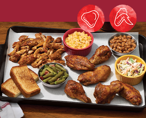 Large platter of smoked chicken wings and pulled chicken with mac and cheese, baked beans, coleslaw, green beans, and toasted bread