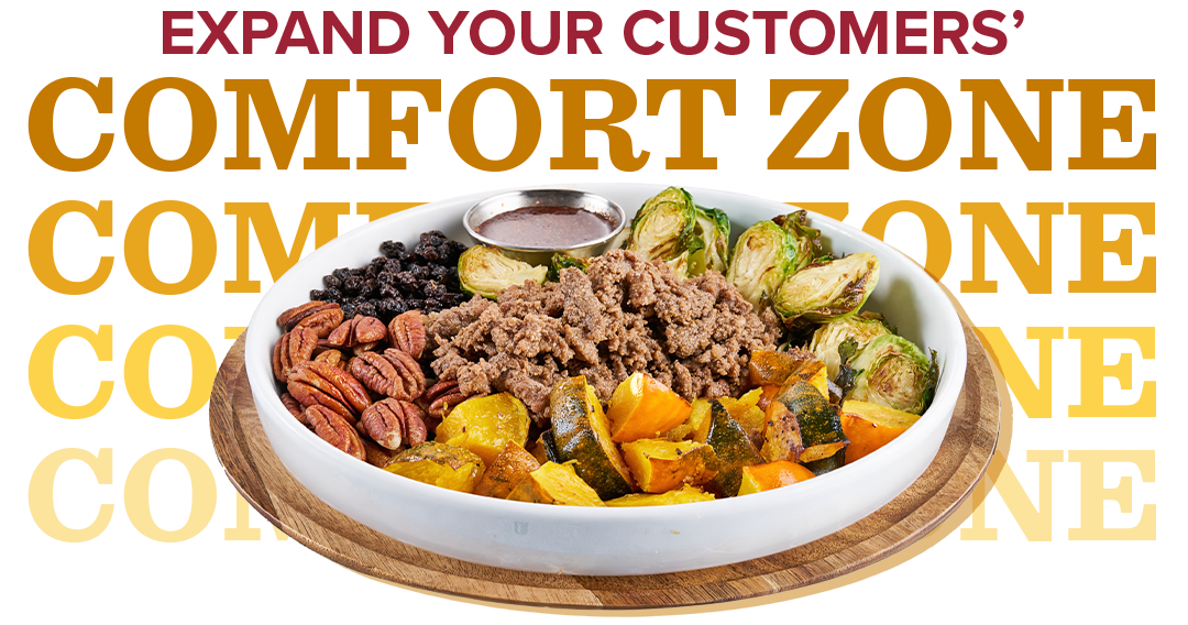 A bowl loaded with sliced beef, acorn squash, pecans, black currants, Brussels sprouts and sauce in a metal ramekin