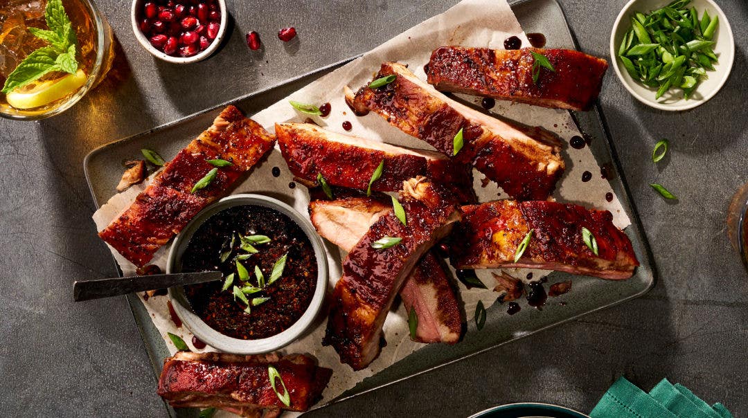 Ribs on a metal tray with BBQ sauce