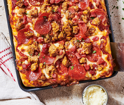 Pizza in a pan topped with cheese pepperoni and sausage