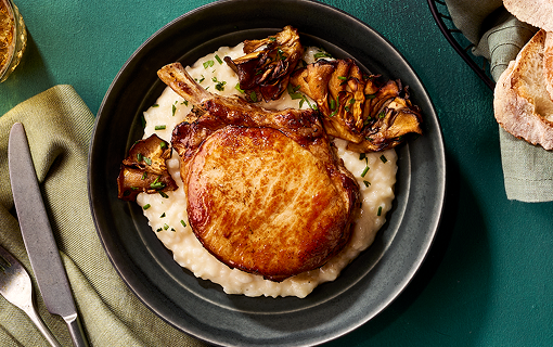 Pork loin ontop of a bed a mashed potatoes