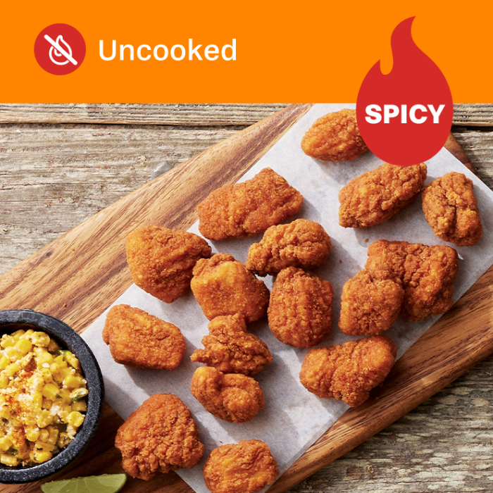 Tyson Red Label® Uncooked Authentically Crispy Spicy Chicken Breast Chunks on a wooden board with a side of pasta