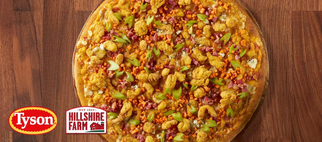 a chicken pizza with melted cheese, bacon, celery and blue cheese crumbles 