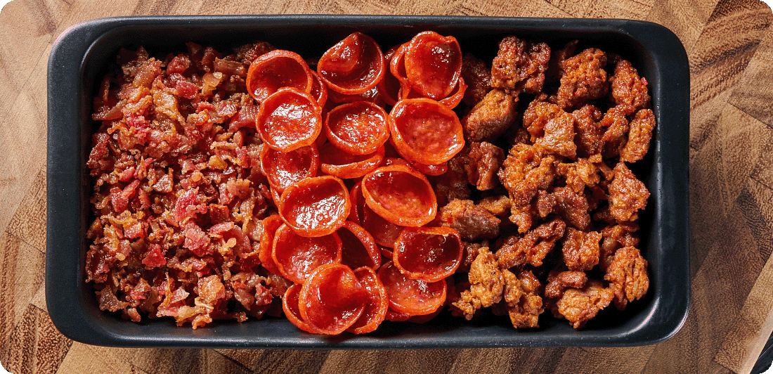 serving dish with pepperoni, sausage and bacon pizza toppings