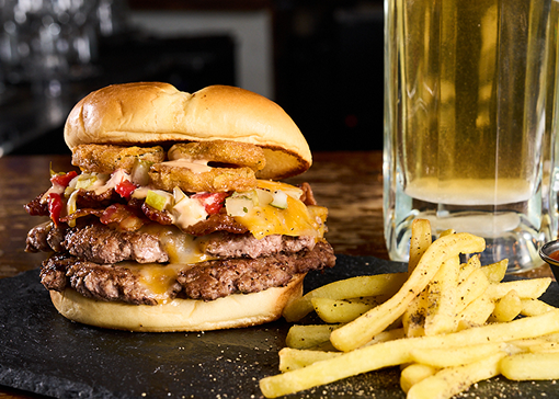 two grilled beef burgers topped with hickory smoked bacon