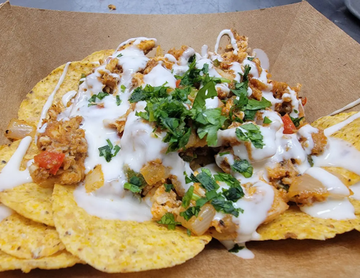 Corn tortilla chips smothered in barbecue sauced pulled chicken, Pico de Gallo and queso 