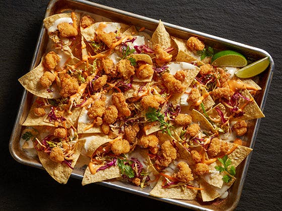 Lightly breaded Tyson® Mini Chicken Bites on Korean-Inspired Chicken Nachos