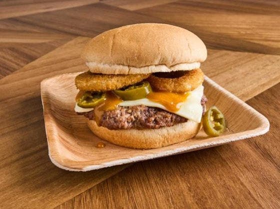 Flame-grilled beef burger with golden BBQ sauce, white American cheese, jalapenos and crispy onion rings on white wheat bun