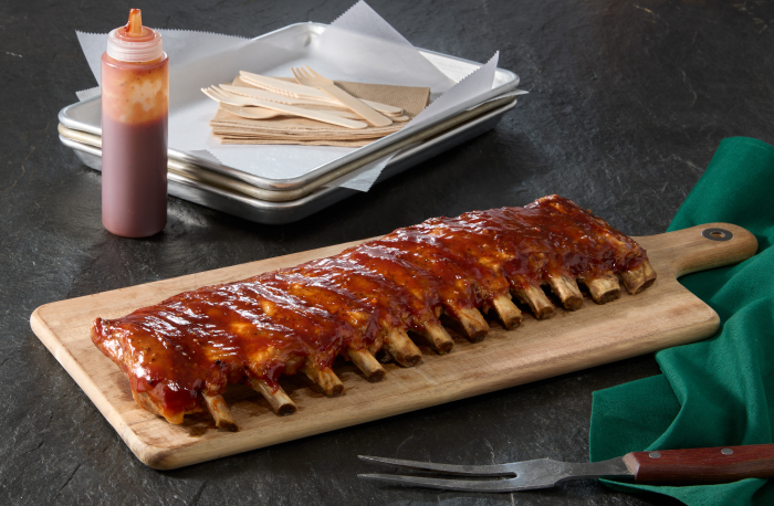 Rack of St. Louis-style pork ribs on wooden platter