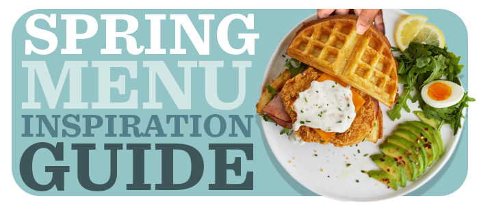 Plate with crispy chicken filet sandwiched between waffles with hardboiled egg and sliced avocado on the side