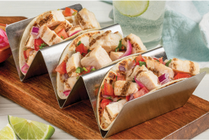 Three chicken tacos on a taco stand with pico salsa