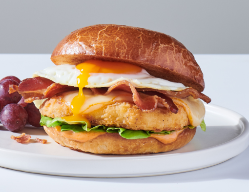 Savory Chicken Breakfast Sandwich on a white plate with a side of grapes
