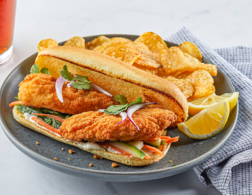 Banh Mi Chicken Sandwich with a side of chips on a grey plate