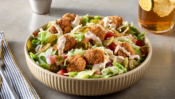 Salad topped with crispy chicken and sauce