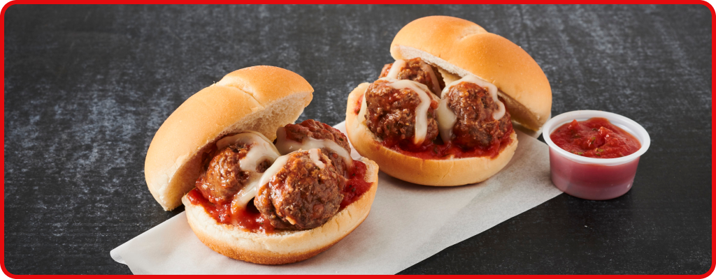 Meatball sandwich topped with marinara sauce and cheese