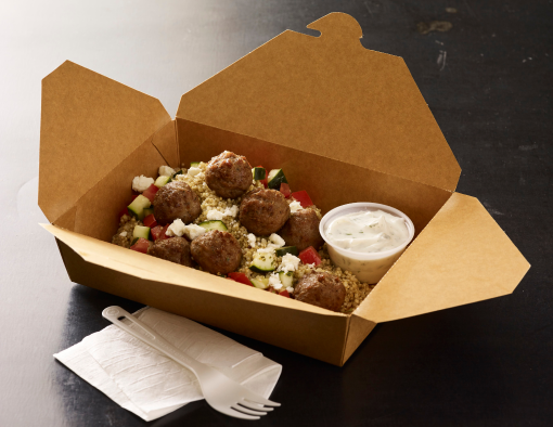 Meatballs served over ancient grains with tomato-cucumber salad, feta cheese and side of tzatziki sauce in to-go container 