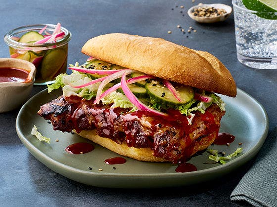 Boneless pork ribs in bulgogi sauce on French roll with Asian-inspired slaw, cucumber coins, and gochujang sauce