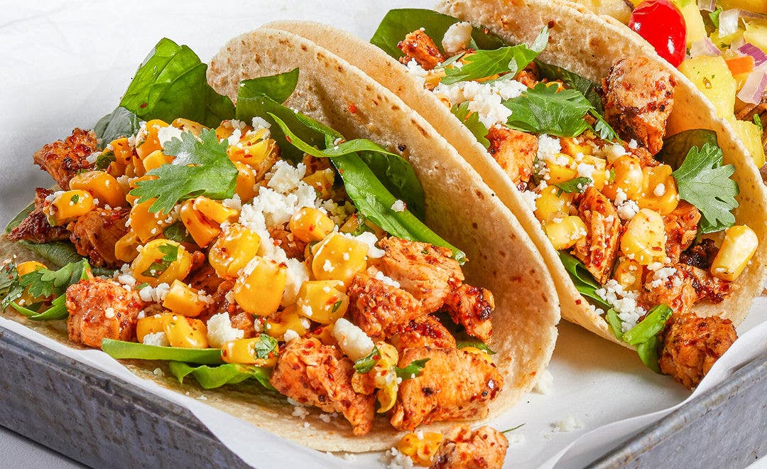 soft corn tortillas stuffed with grilled chicken, Mexican street corn, crumbled cheese and sliced avocados