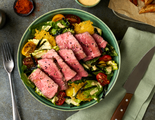 Caesar salad featuring a dressing with toasted nori and sesame seeds, served with grilled beef tenderloin