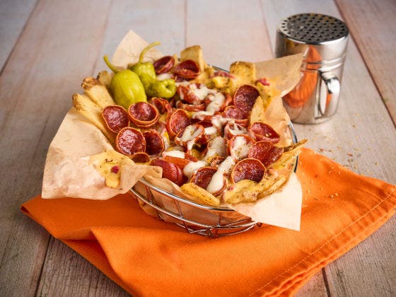 Fries topped with pepperoni, queso, and ranch dressing, served with pepperoncini peppers on the side