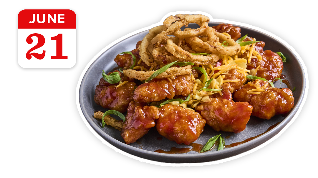 A plate of boneless wings covered in whiskey barbecue sauce, crunchy fried onion strings, and more