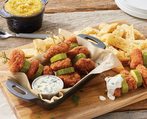Skewers with alternating spicy chicken chunks and pickles with creamy dipping sauce